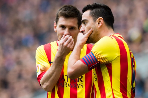 Lionel Messi whispering a secret to Xavi