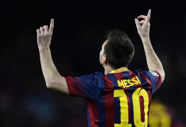 Messi pointing his two fingers to the sky, after scoring a goal for Barcelona