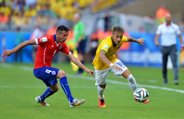 Neymar racing past a defender against Chile, in the FIFA World Cup 2014