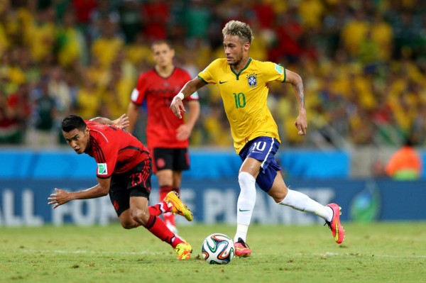 Neymar skipping past a defender in Brazil vs Mexico for the FIFA World Cup 2014