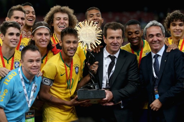 Neymar holding a trophy next to Dunga