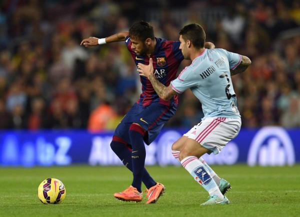 Neymar guarding the ball from a Celta de Vigo defender