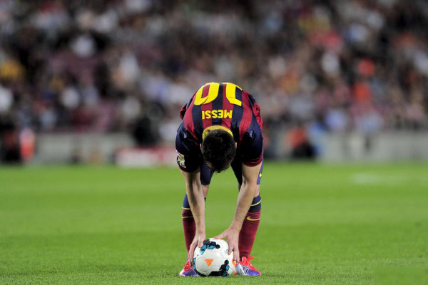 Lionel Messi bends down before taking a free-kick for Barcelona