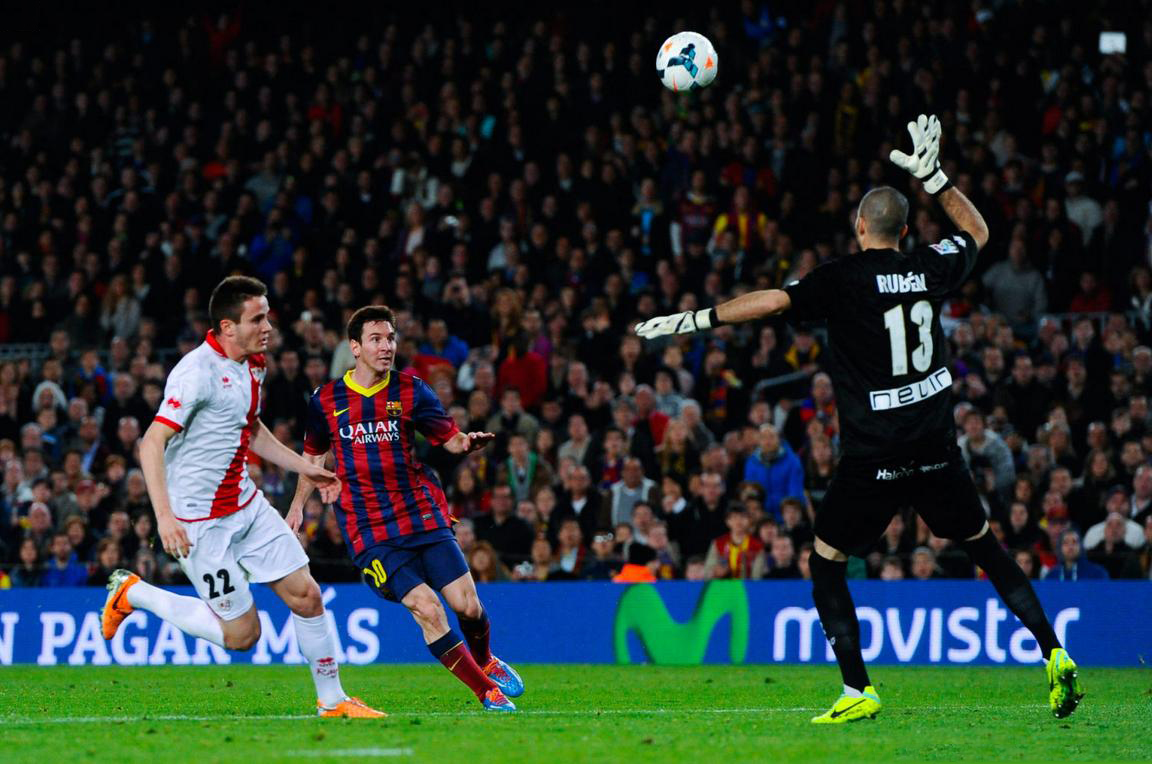 Lionel Messi chipping the ball above the goalkeeper's head