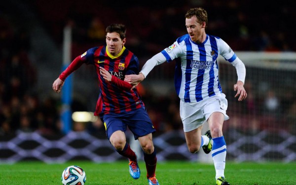 Lionel Messi running away from a Real Sociedad defender