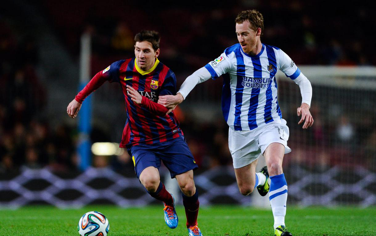 Lionel Messi running away from a Real Sociedad defender