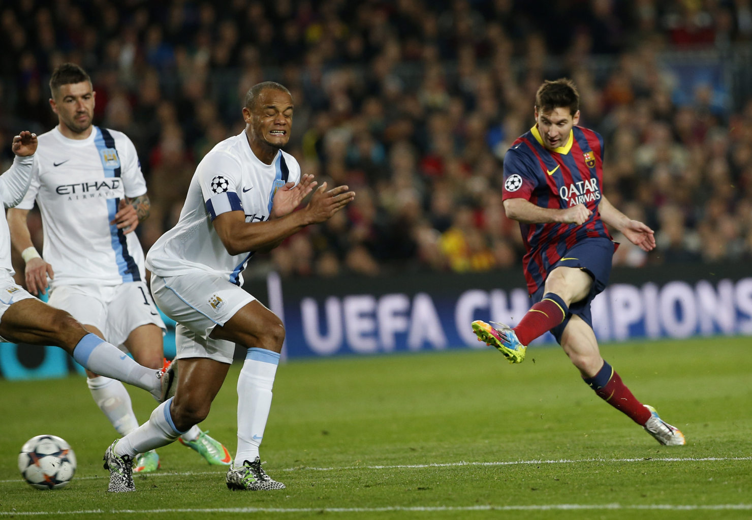 Lionel Messi shooting, with Kompany closing his eyes