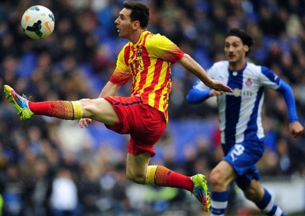 Messi stretching his leg to reach to the ball