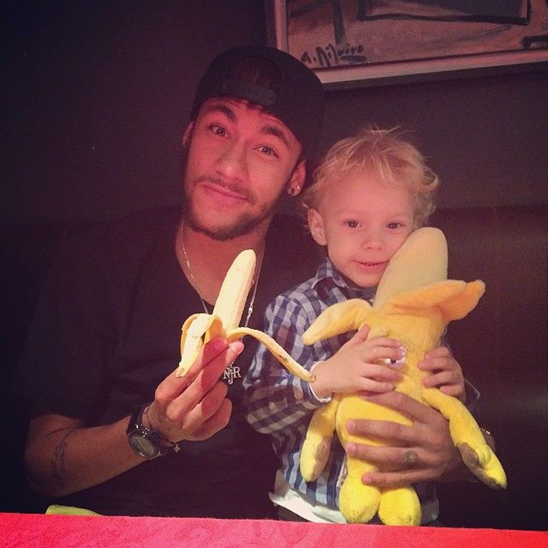 Neymar and his son David Luccas eating a banana in a campaign against Racism