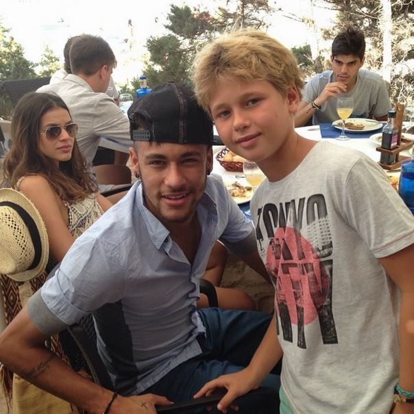 Neymar posing for a photo with a young fan