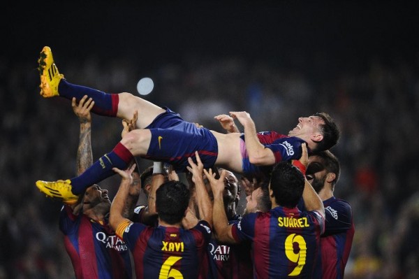 Lionel Messi being thrown to the air by his Barcelona teammates